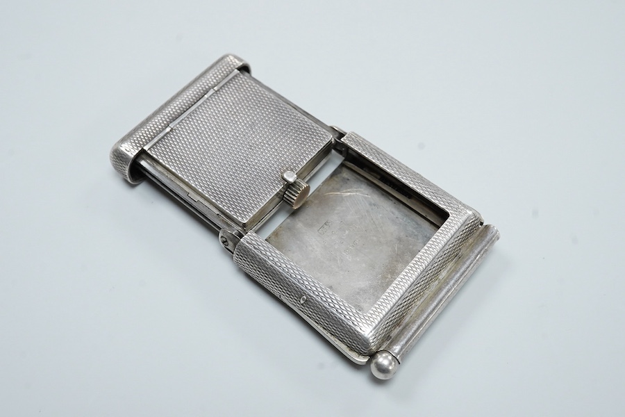An early to mid 20th century engine turned 935 standard white metal combination travelling watch/pencil holder and notepad section, with Arabic dial, 42mm.